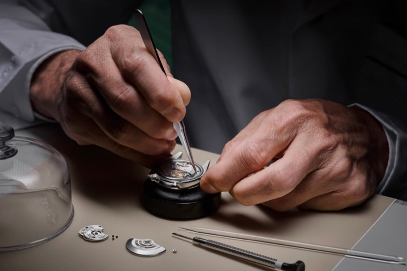 Rolex watchmaker servicing a timepiece at the workbench