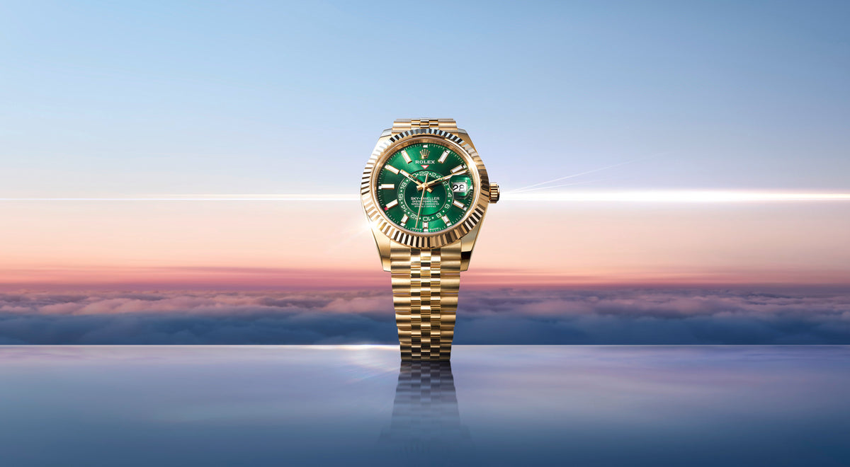 An 18ct yellow gold Rolex Sky-Dweller watch featuring a bright green dial and a matching Jubilee bracelet, set against a sunset sky over clouds.